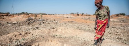 Adelaide Maphangane stands beside an empty water hole in the district of Mabalane, Mozambique.