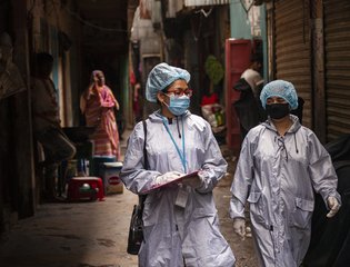 Development workers look at their checklist during an awareness raising drive in Dhaka
