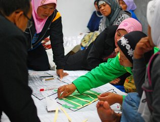 Community meeting discussing reconstruction of village hit by volcanic eruption.  Indonesia.