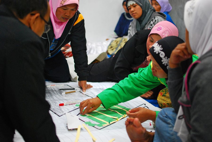 Community meeting discussing reconstruction of village hit by volcanic eruption.  Indonesia.