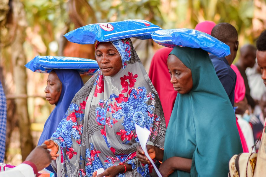Nigeria women in Abuja carrying sacks on their heads while learning about health and hygiene during the COVID-19 pandemic