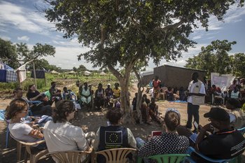 A contingent of European journalists listen to a local liaison officer working with Relief Hope Recovery (GOA), one of several partners of the European Commission’s Civil Protection and Humanitarian Aid department (ECHO) at Rhino refugee settlement.