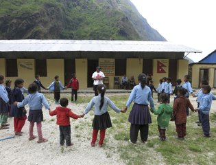 A volunteer from the Nepal Red Cross Society engages children to play games in order to overcome the trauma from hundreds of aftershocks of an earthquake.