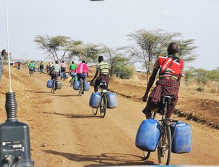 a-group-of-people-riding-bikes-down-a-dirt-road