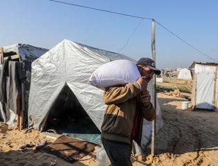 UNRWA and the World Food Organization distribute bags of flour to displaced Palestinians